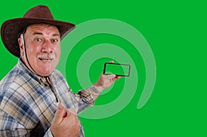 A farmer is very happy holding a mobile phone with a chroma key screen in his hand