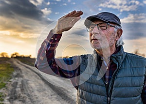 Farmer walking on dirt road and waving hand