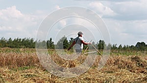 Farmer is walking wheat field with wooden tool for measuring the area cultivated cereal. agronomist inspect own farmland