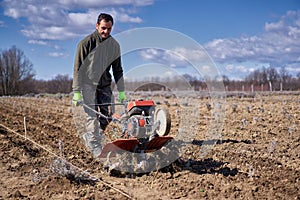 Farmer weeding the field with a tiller