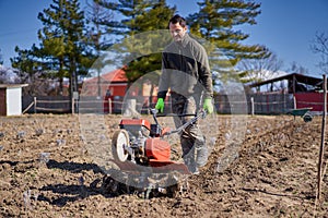 Farmer weeding the field with a tiller