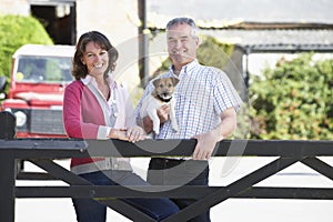 Farmer And Wife Looking Over Farm Gate