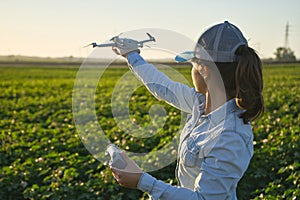 Farmer woman checks the field with dron