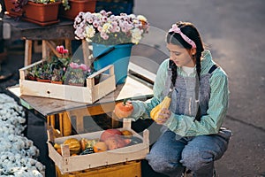 Farmer woman decor a wooden box with small pumpkins