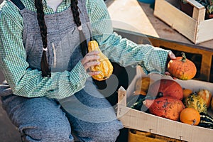 Farmer woman decor a wooden box with small pumpkins