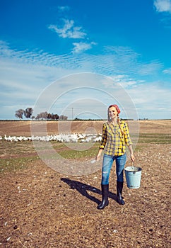 Farmer woman feeding the geese