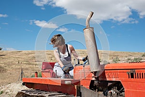 Farmer woman maneuvering a tractor on her farm