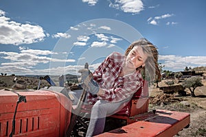 Farmer woman maneuvering a tractor on her farm