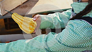 Farmer woman takes out a small pumpkin from a wooden box