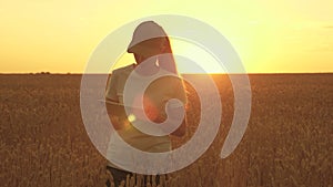 Farmer woman in wheat field at sunset. Organic grain on plantation. Agronomist woman farmer, business woman looks into a