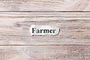 Farmer of the word on paper. concept. Words of Farmer on a wooden background