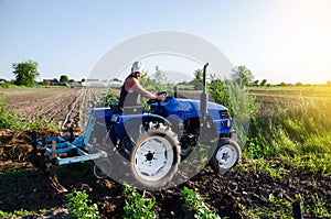 The farmer works in the field with a tractor. Agroindustry and agribusiness. Field work cultivation. Farm machinery. Crop care