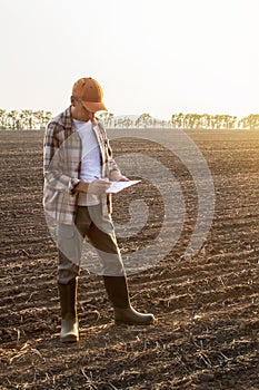 Farmer writing check list in a fi