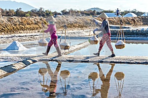 Farmers carrying salt on embankment