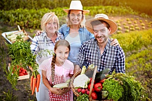 Farmers family holding vegetables from garden