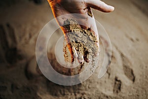 A farmers hands in the fertile ground, with selective focus on the palms