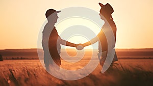 Farmers handshake a success silhouette in wheat field. Agriculture business concept. Farmers contract handshake success