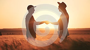 Farmers handshake a success silhouette in wheat field. Agriculture business concept. Farmers contract handshake success