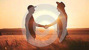 farmers handshake a success silhouette in wheat field. agriculture business concept. farmers contract handshake success