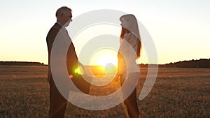 Farmers man and woman made a deal. businessman and businesswoman shaking hands in glow of the sunset. Business woman