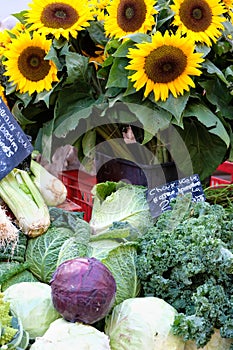 Farmers market stall Provence France vegetables and sunflowers.