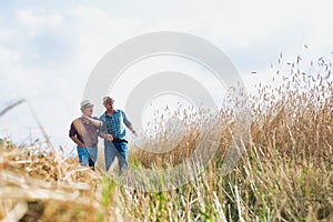 Farmers walking while talking against wheat field