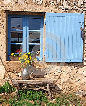 Farmhouse window with blue shutter