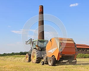 Farmig tractor in hay field