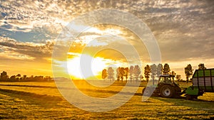 Farming field at sunrise with farm tractor truck