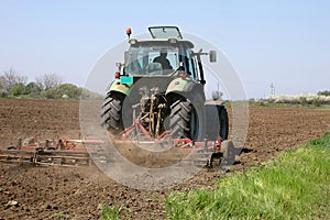 Farming a field with a tractor photo