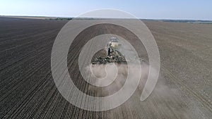 Farming, seeding machine with plow sows grain in soil of field at planting season at spring