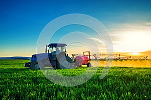 Farming tractor plowing and spraying on field