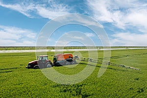 Farming tractor plowing and spraying on field.