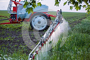 Farming tractor plowing and spraying on field