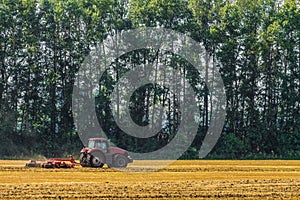 Farming tractor is working in the field