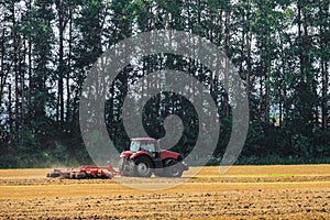 Farming tractor is working in the field