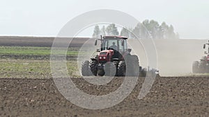 Farming tractors moving on agricultural field for plowing land. Agricultural tractor plowing farming field