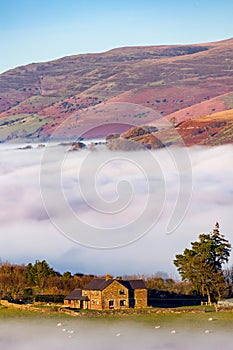 Farmland above low lying fog and a cloud inversion in the Brecon Beacons, Wales