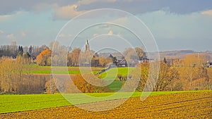 Farmland and bare trees under a colorful winter sky in the flemish countryside photo