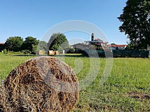 Farmlands in italy with haybales and church photo