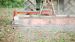 Farmworker riding tractor tilling or plowing the earth. Preparation to cultivate in agricultural field. Traditional agriculture in photo
