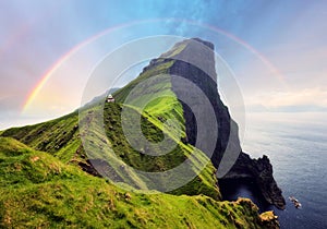 Faroe Island in Denmark with rainbow - Kallur lighthouse on green hills of Kalsoy island on sunset time, Landscape photography