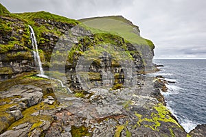 Faroe islands landscape with waterfall and atlantic ocean. Mikladalur, Kalsoy photo