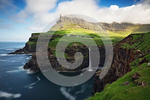 Faroe Islands waterfall Malafossu near village Gasadalurron the Island Vagar. Green mountain caost landscape photo