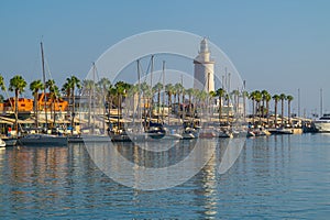 Farola de Malaga surrounded by boats and the sea on a sunny day in Spain photo
