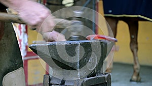 A farrier forging a horseshoe