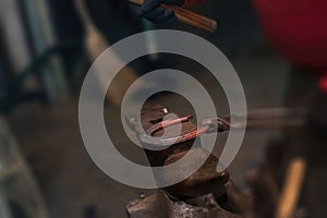 Farrier forging horseshoe on anvil