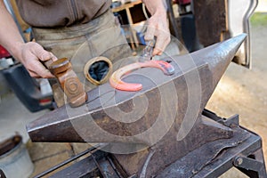 Farrier making horse` hoof