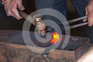 farrier making a traditional horseshoe on a forge
