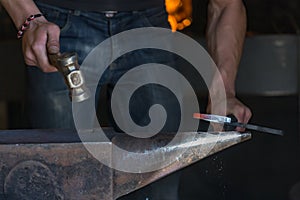 farrier making a traditional horseshoe on a forge